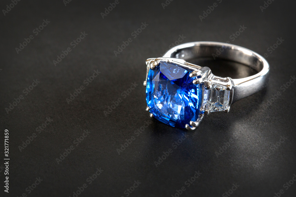 Ring of the jewelry with dark blue sapphire on the black background Ring of the jewelry with dark blue sapphire on the black background