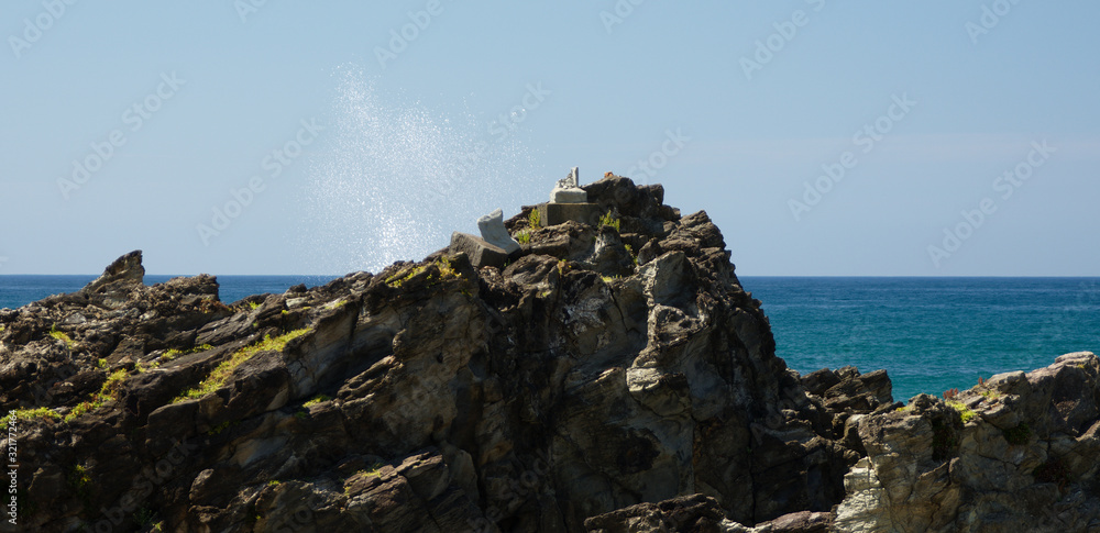 Wave crash spray on coastal rocks