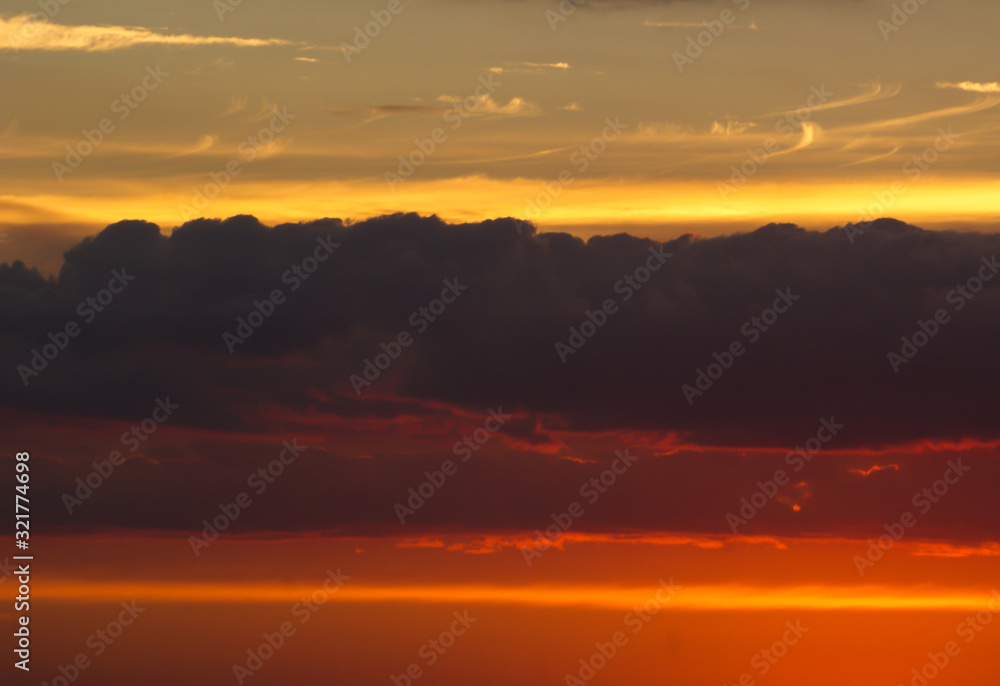 Fototapeta premium Blue-orange sky with clouds at sunset.