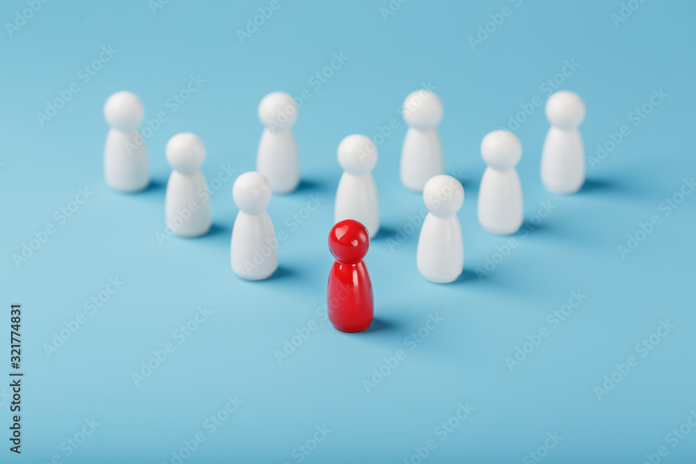 The leader in red leads a group of white employees to victory, HR, Staff recruitment. The concept of leadership. The leader in red leads a group of white employees to victory, HR, Staff recruitment. The concept of leadership.