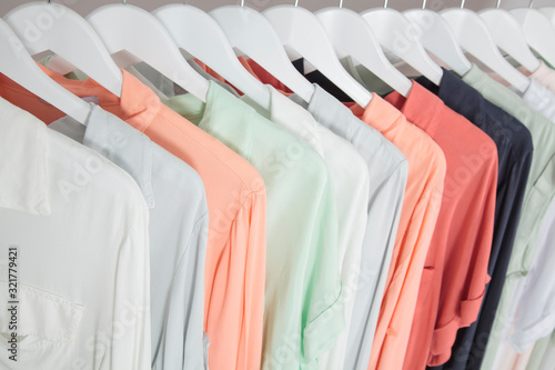 Colourful clothing on white hangers