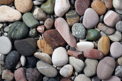 Gravel pattern of colored stones. Abstract nature pebbles background.Small sea stones on the beach, vacation at sea. Top view 