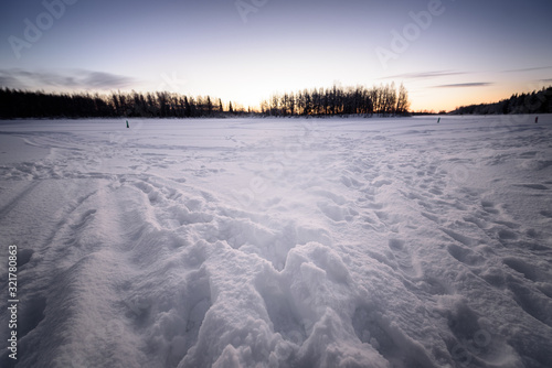 The ice lake and forest has covered with heavy snow and nice blue sky in winter season at Holiday Village Kuukiuru  Finland.