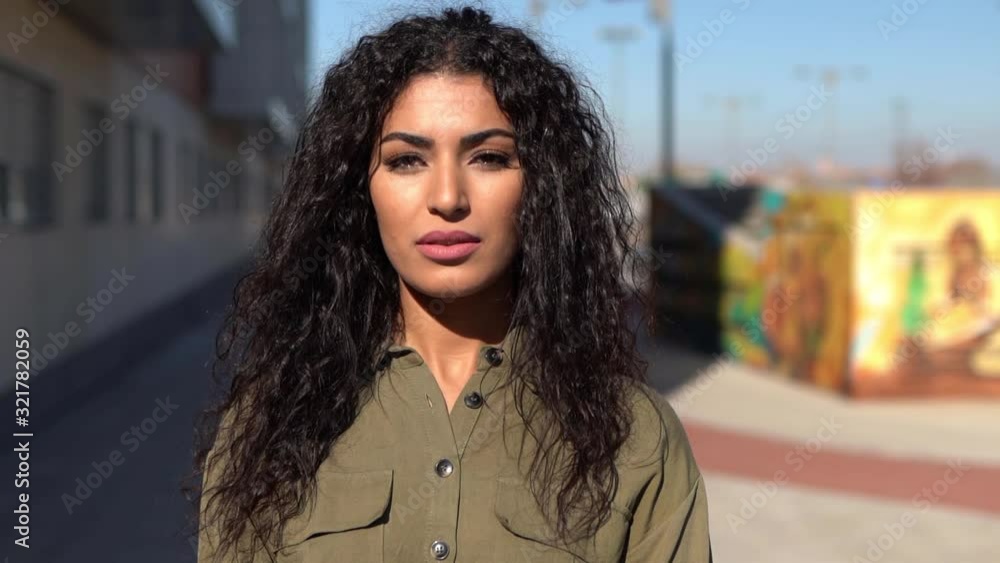 Young Arab woman moving her black curly hair Young Arab woman moving her black curly hair