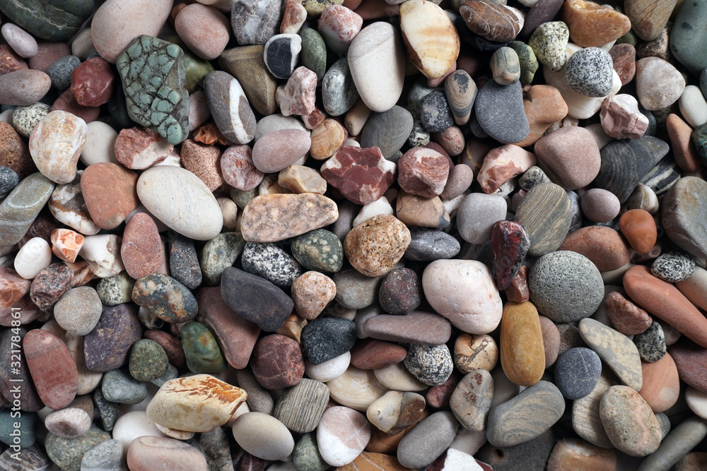 Gravel pattern of colored stones with shell. Abstract nature pebbles background.Small sea stones on the beach, vacation at sea. Top view Gravel pattern of colored stones with shell. Abstract nature pebbles background.Small sea stones on the beach, vacation at sea. Top view