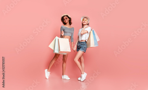 Two Stylish Girls With Shopper Bags Posing On Pink Background