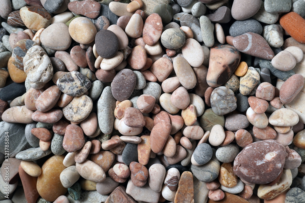 Gravel pattern of colored stones with shell. Abstract nature pebbles background.Small sea stones on the beach, vacation at sea. Top view Gravel pattern of colored stones with shell. Abstract nature pebbles background.Small sea stones on the beach, vacation at sea. Top view