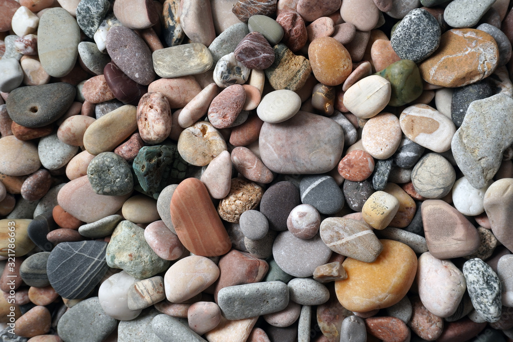 Gravel pattern of colored stones with shell. Abstract nature pebbles background.Small sea stones on the beach, vacation at sea. Top view Gravel pattern of colored stones with shell. Abstract nature pebbles background.Small sea stones on the beach, vacation at sea. Top view