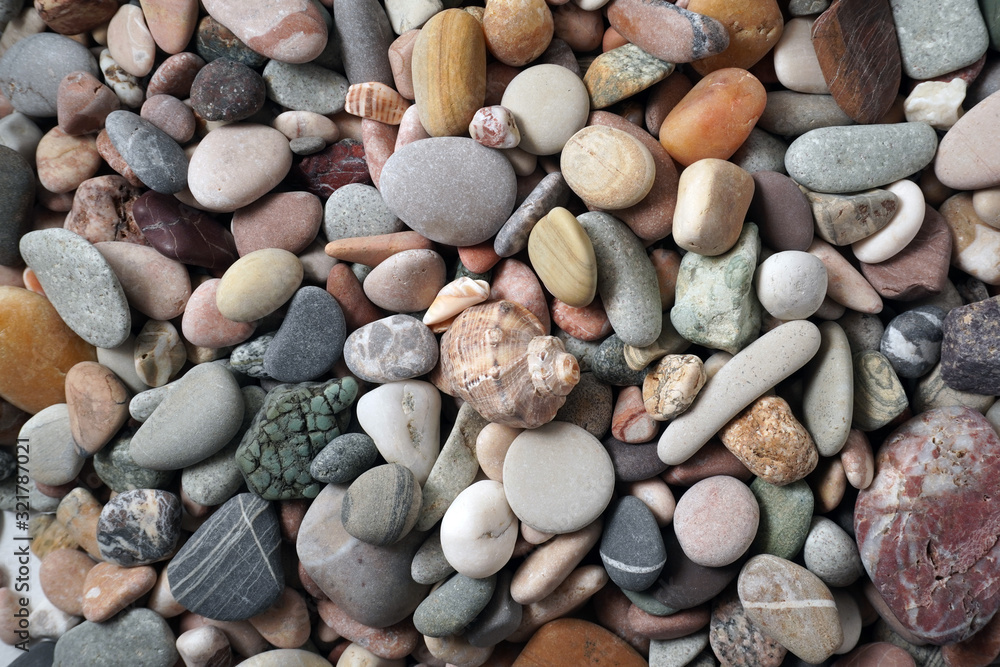 Gravel pattern of colored stones with shell. Abstract nature pebbles background.Small sea stones on the beach, vacation at sea. Top view Gravel pattern of colored stones with shell. Abstract nature pebbles background.Small sea stones on the beach, vacation at sea. Top view