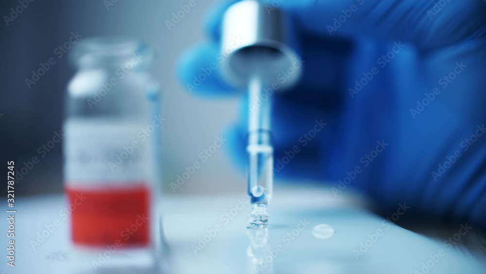 Hand in sterile glove puts droplet with an eye dropper Hand in sterile glove puts droplet with an eye dropper