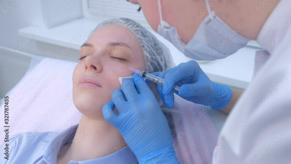Cosmetologist doctor making multiple injections biorevitalization in woman face skin under eye, portrait closeup. Mesotherapy and face lifting in beauty clinic. Beautician's hands and girl's face. Cosmetologist doctor making multiple injections biorevitalization in woman face skin under eye, portrait closeup. Mesotherapy and face lifting in beauty clinic. Beautician's hands and girl's face.