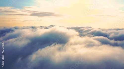 Aerial clouds flying sky in motion. Aerial view white clouds in blue sky during sunrise or sunset. Aerial top view cloudscape. Texture of clouds. Panoramic view. Clouds in motion. Fast playback photo