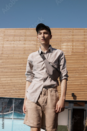  A guy in a cap and shorts with a waist bag on the street