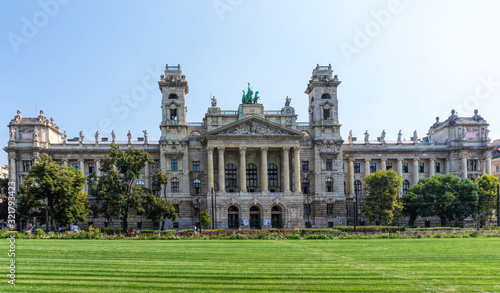 Budapest / Hungary - August 29 2019: Facade of the historic luxury building of the Ethnographic Museum in Budapest, Hungary. Ancient building with columns against the blue sky and green city park