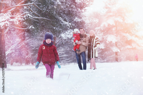 Young family with children are walking in the winter park. Winter walk of parents with children. Walking on a holiday weekend in the winter.