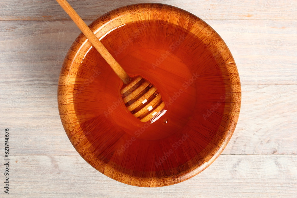 Honey with Honey Dipper in Wooden Bowl Honey with Honey Dipper in Wooden Bowl