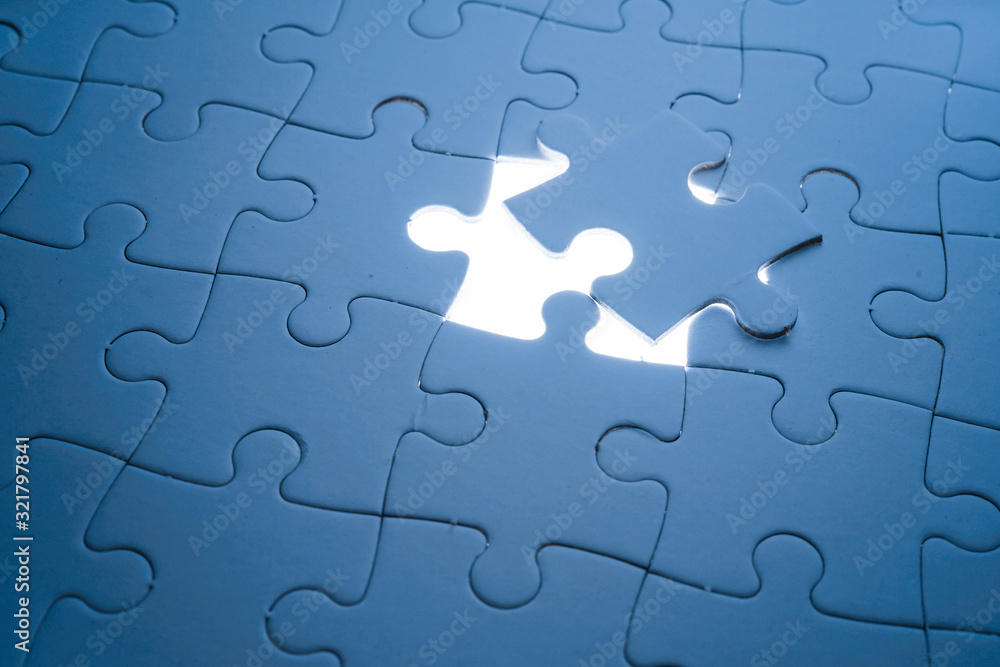 Missing piece of jigsaw puzzle with light glow, business concept for completing the final puzzle piece Missing piece of jigsaw puzzle with light glow, business concept for completing the final puzzle piece