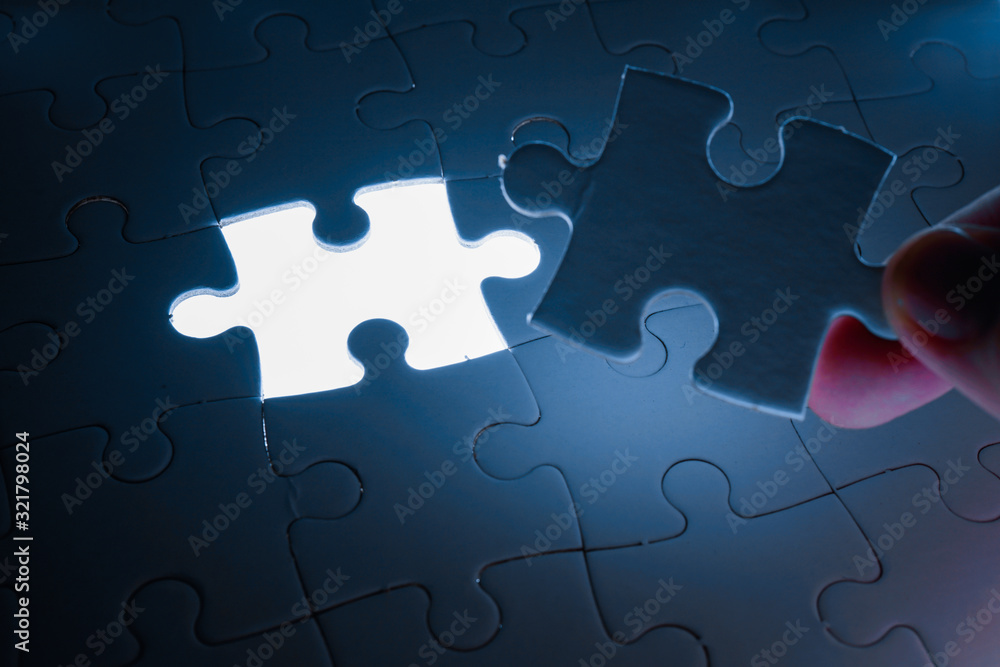 Missing piece of jigsaw puzzle with light glow, business concept for completing the final puzzle piece Missing piece of jigsaw puzzle with light glow, business concept for completing the final puzzle piece