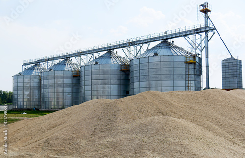 A pile of wheat near the grain towers.