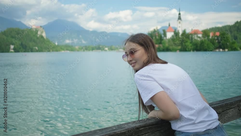 Girl looking at Lake Bled from the wooden bridge, Slovenia Girl looking at Lake Bled from the wooden bridge, Slovenia