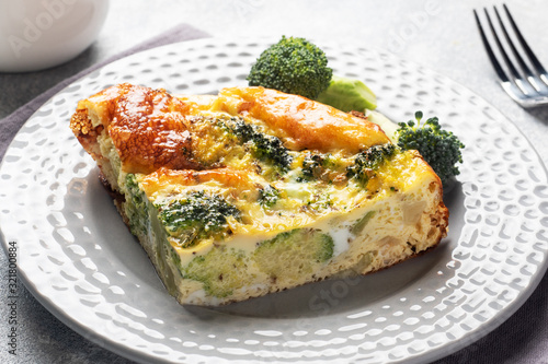 Piece Baked omelet with broccoli on a plate. Concrete table. Healthy diet food dish.