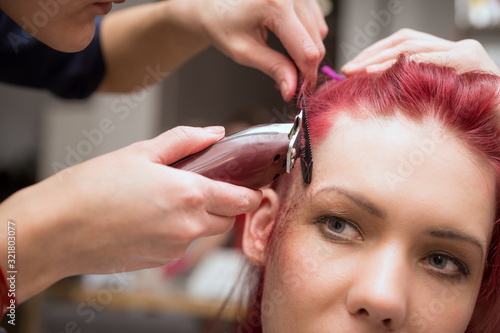 The hairdresser selects whiskey for the girl to create a stylish hairstyle.