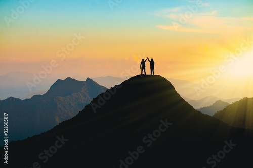 Photography The silhouette of lovers on the top of the mountain During sunset time
