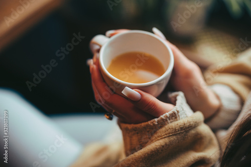 Woman hands holding cup with tea in cafe