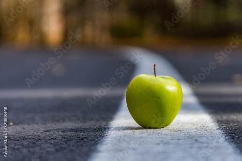 Conceptual landscape with a green apple on the leading lines of the road,Sfanta Ana, Romania photo