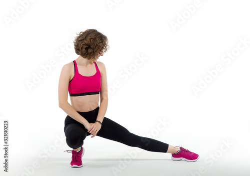 Young woman doing stretching before going in for sports on a white background. Warm up, fitness exercise.