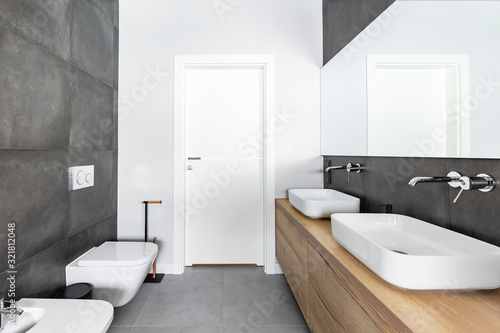 Double sinks in elegant white  concrete and wooden bathroom interior