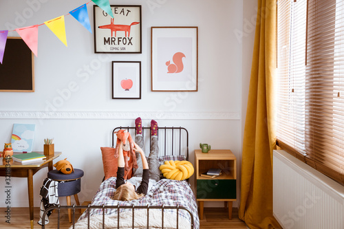 Cute vintage style posters on white wall of trendy bedroom for child photo