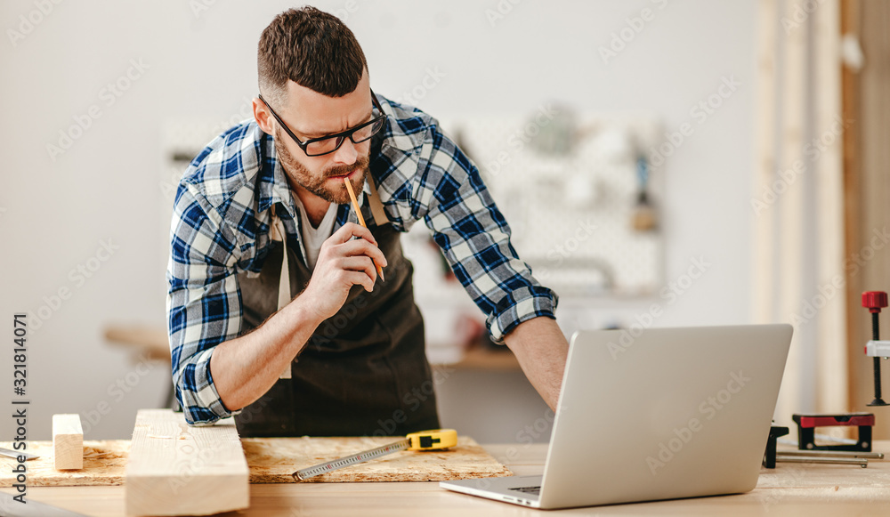 young male carpenter working in workshop. young male carpenter working in workshop.