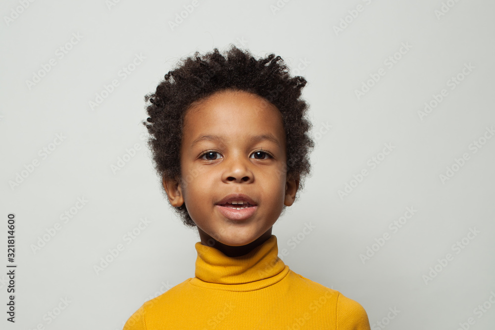 Happy black child boy in yellow turtleneck sweater smiling on white background Happy black child boy in yellow turtleneck sweater smiling on white background