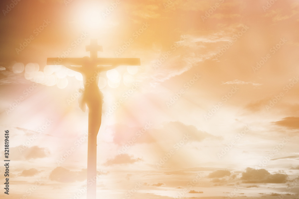 silhouette Jesus Christ crucifixion on cross over orange sunset light