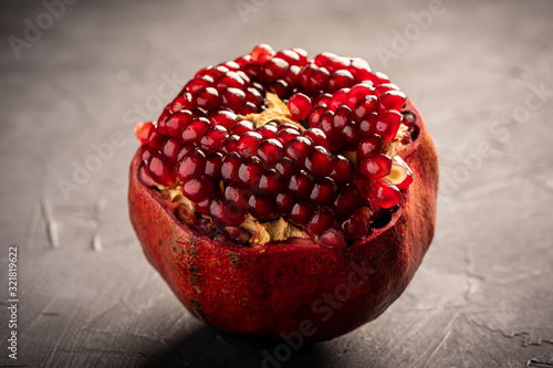 Fresh pomegranate on dark surface photo