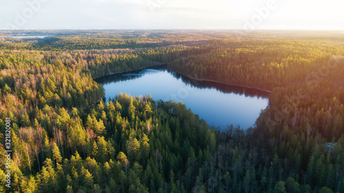 Fototapeta Naklejka Na Ścianę i Meble -  Aerial view of small blue lake in the green forest at sunset in Finland, Nuuksio.