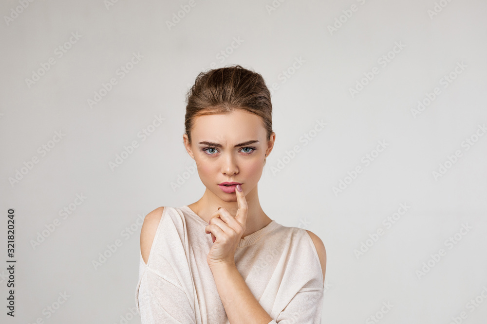 Portrait of cute brunette woman thinking about something on gray background. Human emotions, facial expression concept. Portrait of cute brunette woman thinking about something on gray background. Human emotions, facial expression concept.