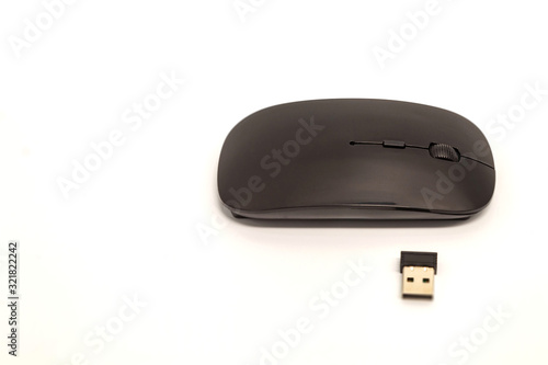 A black small computer mouse without a wire lies on a white background