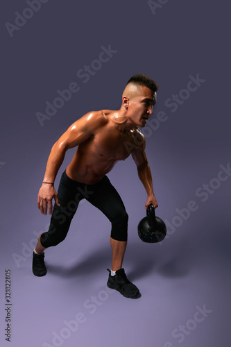 young ambitious awesome man spending time at sport center, full length photo. isolated gray background, studio shot