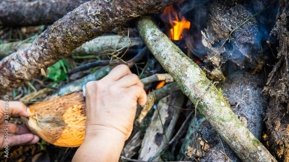 Close up view of hand making a campfire using the dried tree branches. Close up view of hand making a campfire using the dried tree branches.