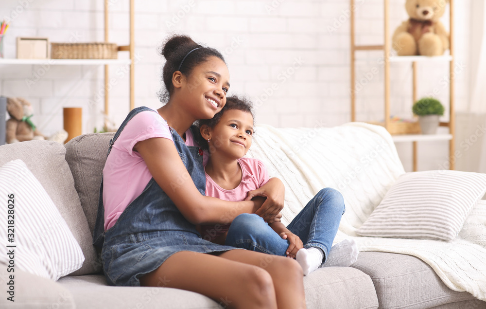 Cheerful african sisters embracing at home, free space Cheerful african sisters embracing at home, free space