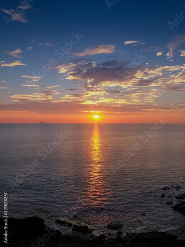 view seaside evening of many clouds moving above the sea with red sun light and cloudy sky background sunset at Tanod Cape (Laem Tanod), Mu Ko Lanta National Park, Lanta island, Krabi, south Thailand. photo