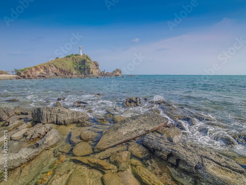 view of many arch rocks in blue-green sea with lighthouse on top hill and blue sky background, Laem Tanod (Tanod Cape), Mu Ko Lanta National Park, Lanta island, Krabi, southern of Thailand. photo