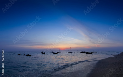 view seaside evening of fishing boats floating in the sea with orange sun light and blue sky background  sunset at Klong Hin Beach  Ko Lanta island  Krabi  southern of Thailand.