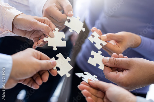 A group of business people assembling jigsaw puzzle.