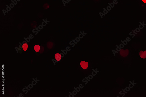 Abstract blur defocused background black, red lights highlights, bokeh hearts, soft focus