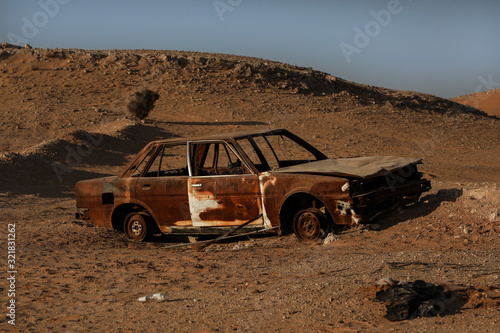 abundan car left to rust in desert photo