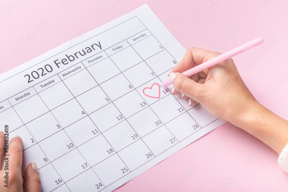 Saint Valentine Day in heart shape circle, woman drawing in calendar Saint Valentine Day in heart shape circle, woman drawing in calendar