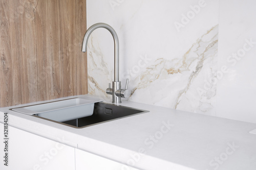 Kitchen sink and faucet on white kitchen photo